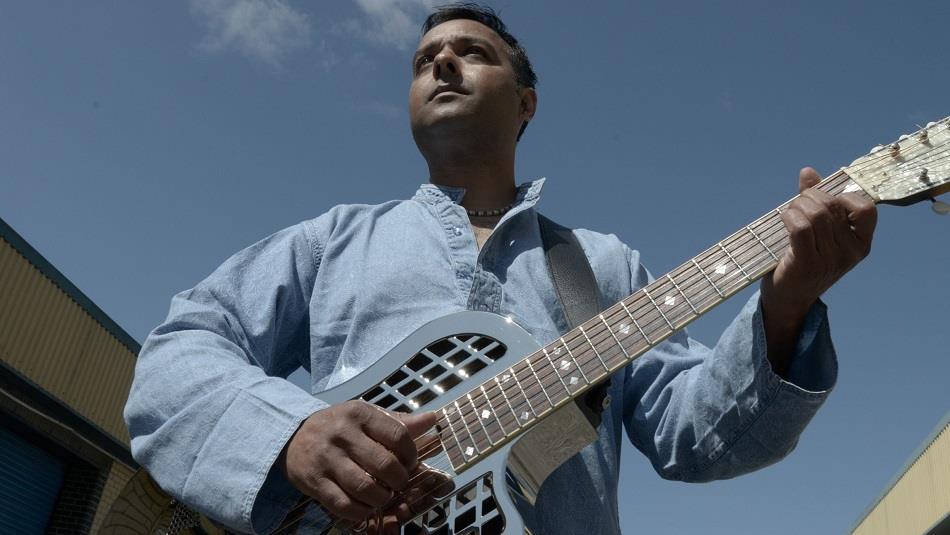 Photo of Ajay holding guitar
