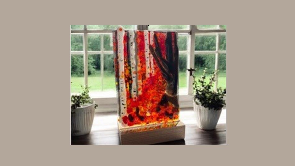 A piece of fused glass artwork on a windowsill