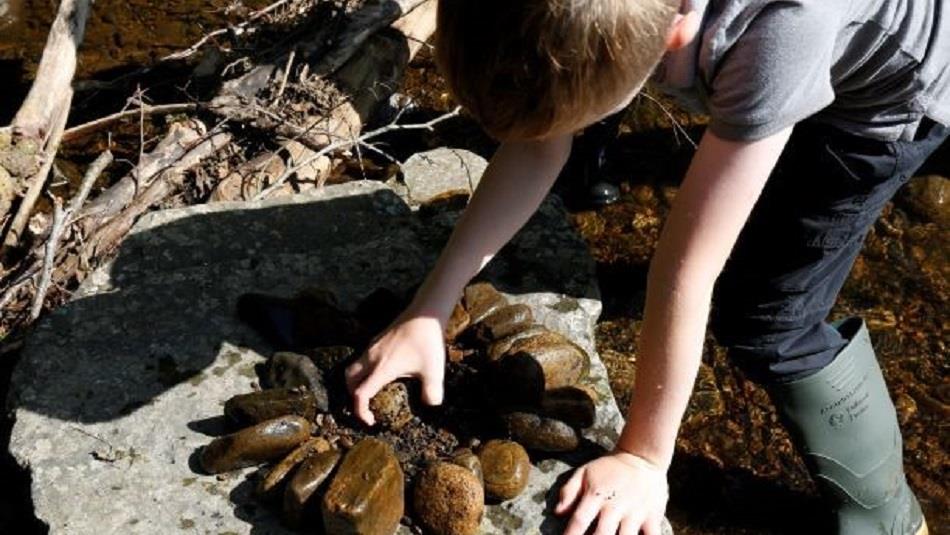 Boy making a design/pattern with rocks