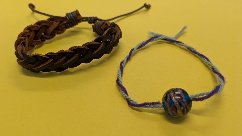 Two bracelets:1 plaited leather,1 wool and glass bead