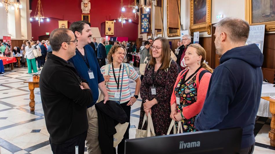 A group of attendees chatting and smiling in a circle during a conference networking session.