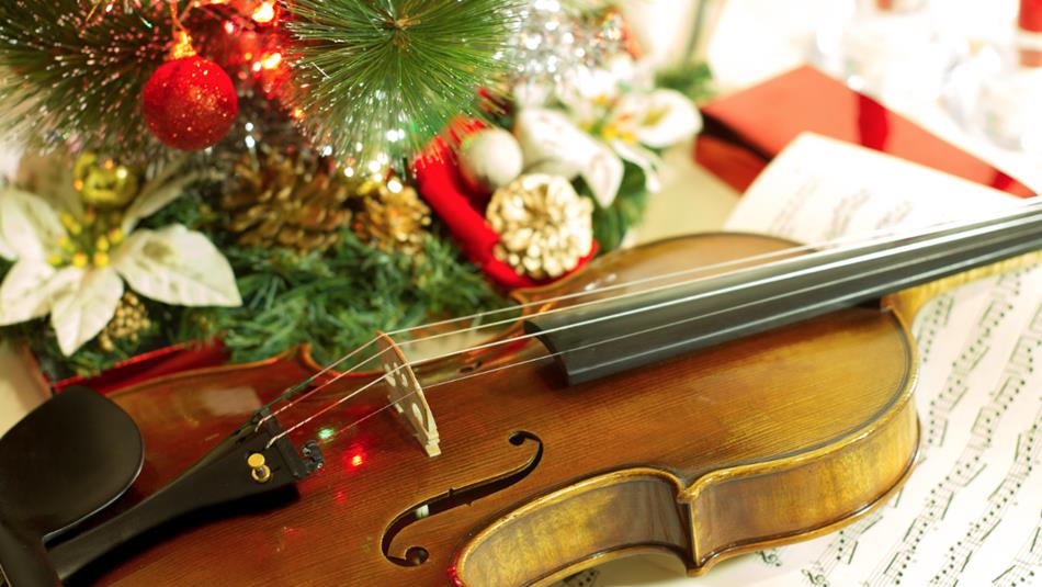 A violin and sheet music with Christmas decorations