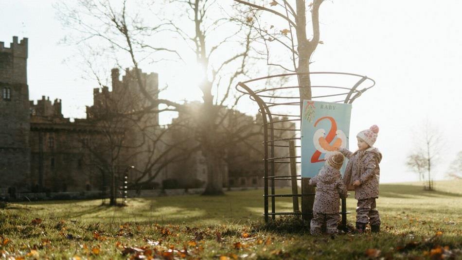 Image of two children wrapped in warm clothes in the grounds of Raby Castle.