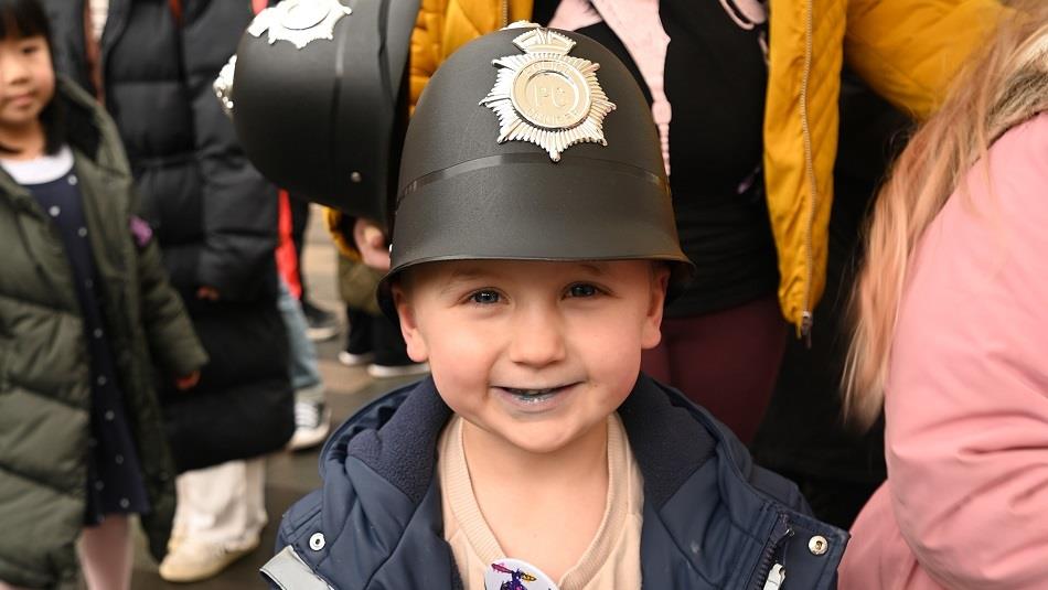 Enjoying Uniformed Services Fun Day in Durham small child wearing a police helmet