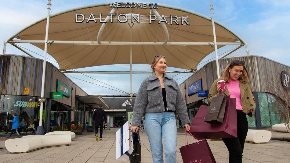 Shoppers leaving Dalton Park Outlet & Outdoors smiling.