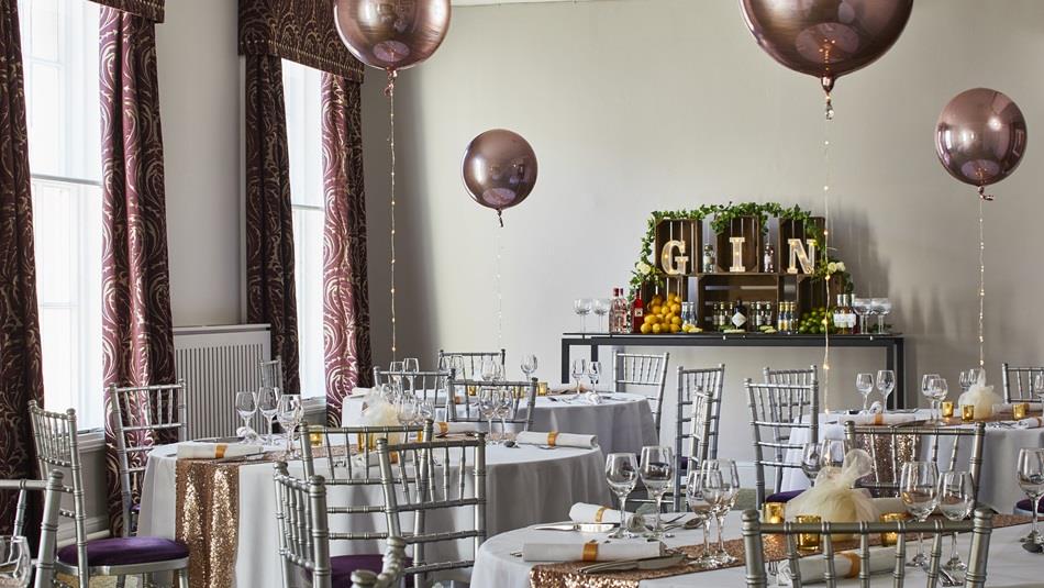 A room at the Durham Marriott set up for a Christmas Party with balloons and table decorations