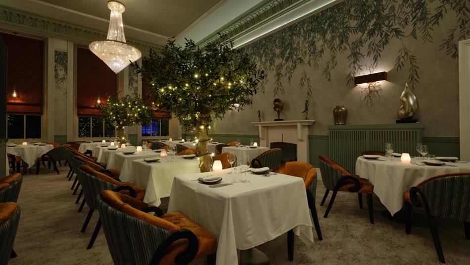 The Dining Room at Seaham Hall Hotel with tree decorations and candlelit tables.