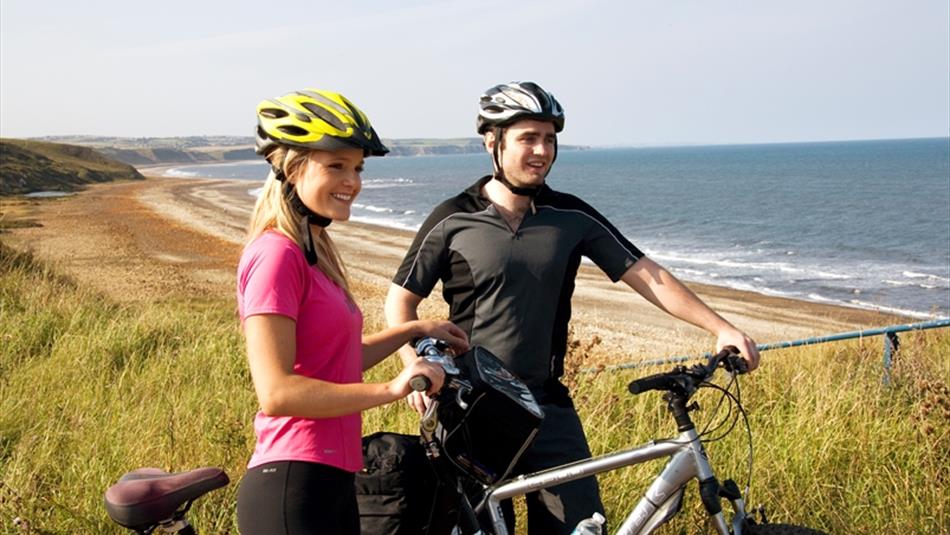 Two people on bikes at the coast