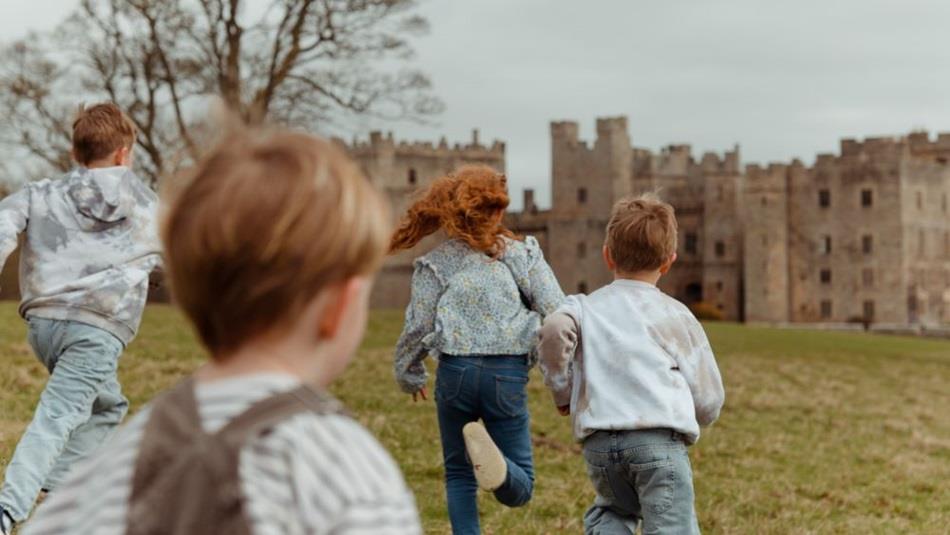 Two children running towards Raby Castle.
