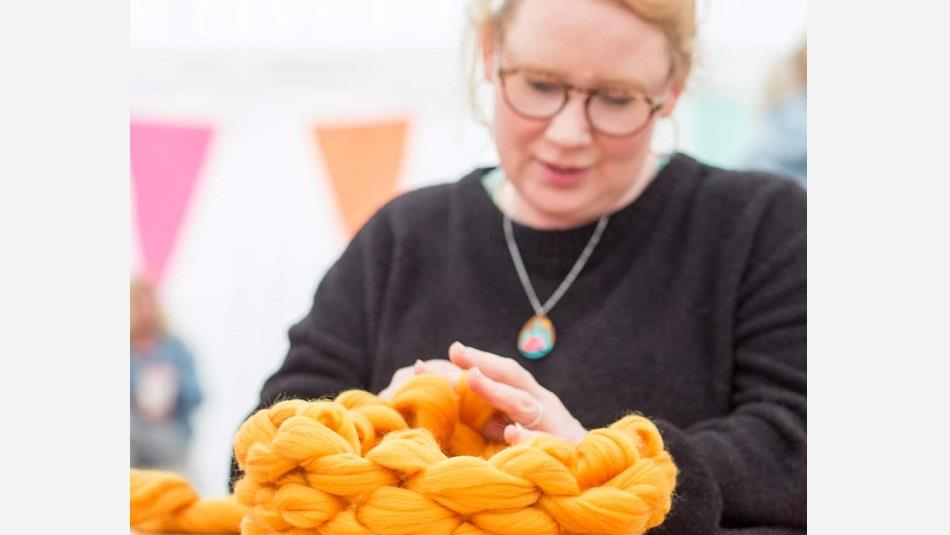 A woman demonstrating finger crochet