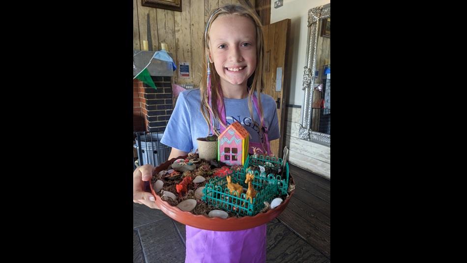 A child holding an example of a craft made in the workshop.