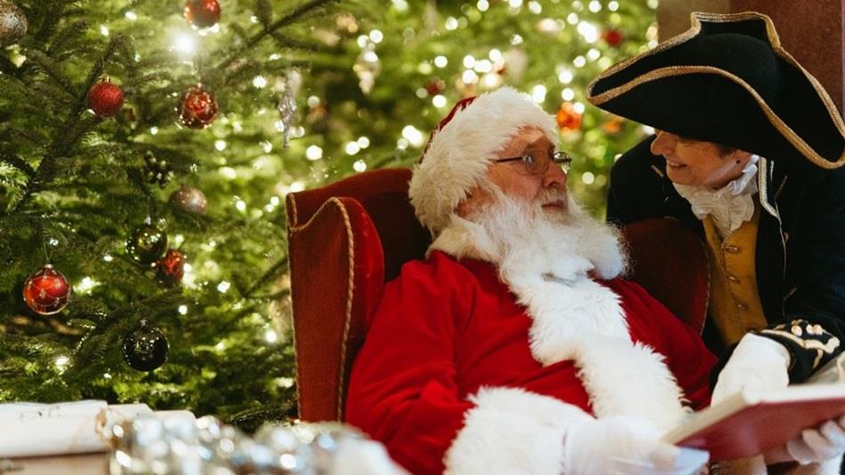 Father Christmas sitting in front of a Christmas Tree at Raby Castle