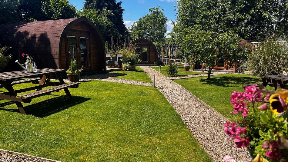 Camping pods, picnic bench, flowers