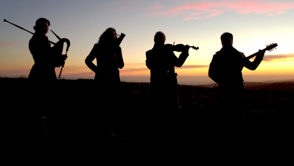 Four musicians silhouetted against a winter sunrise, holding various early musical instruments