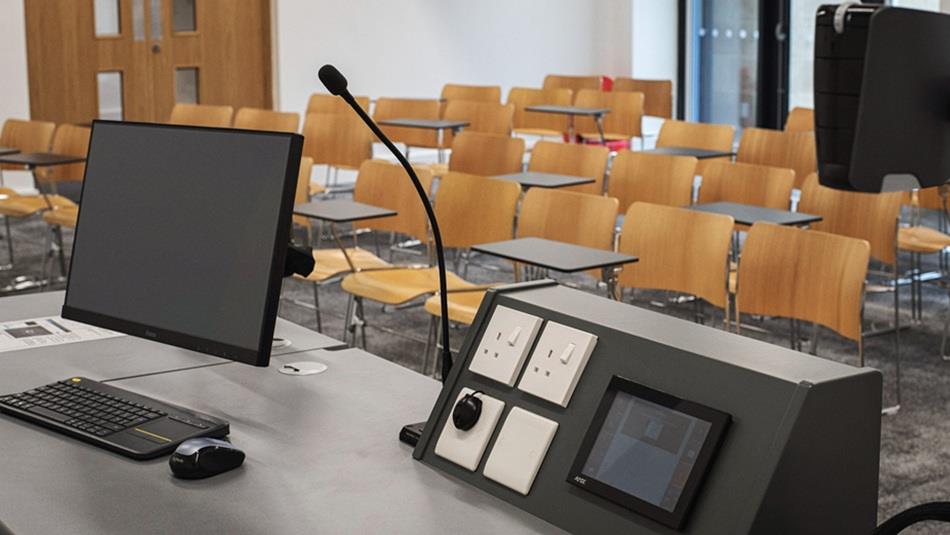 Room set up for a conference at St. John's College showing a computer and microphone facing rows of chairs.