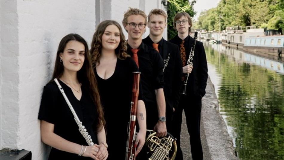 The five members of Lumas Winds holding musical instruments