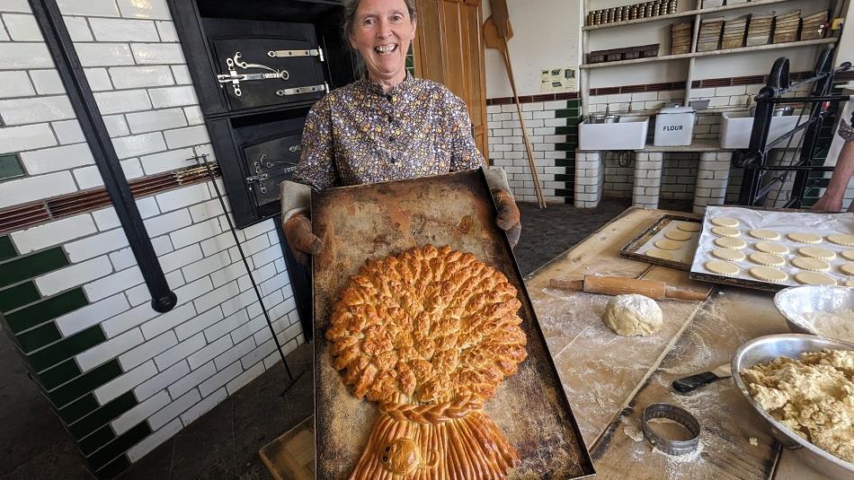 Baker making a large, decorative loaf of bread at Beamish Museum
