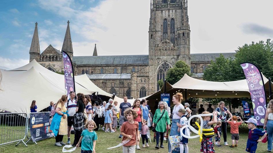 Crowds of people enjoying the Durham Fringe Festival on Palace Green, Durham City.