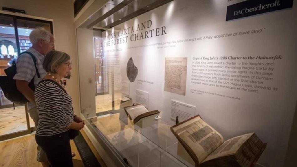 Two visitors to the Cathedral Museum looking at the Magna Carta display from 2017