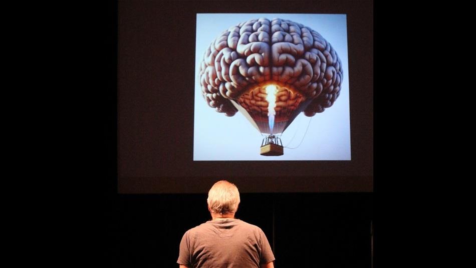 man looking at a hot air balloon in the shape of a brain