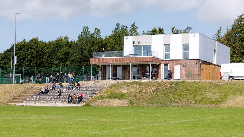 People sitting on stands at Beamish Football Centre (view from pitch).