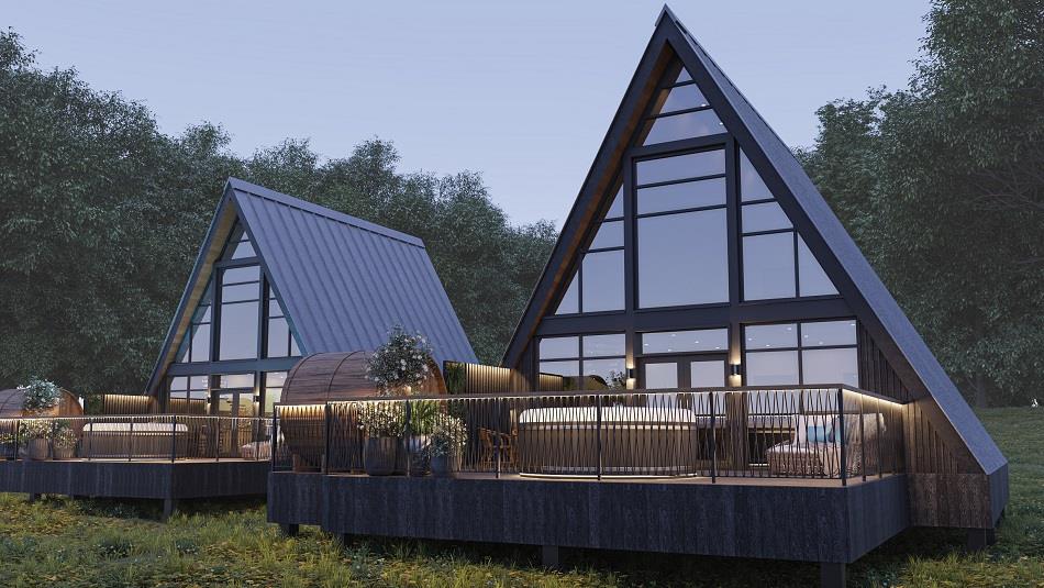 Exterior View of Treehouses set in woodland with full height windows which allow natural light to flood in and wrap around balcony with sunken hot tub