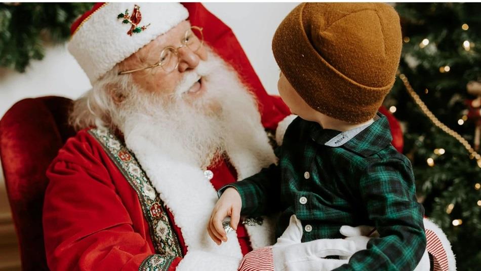 A small child sitting on Santa's knee