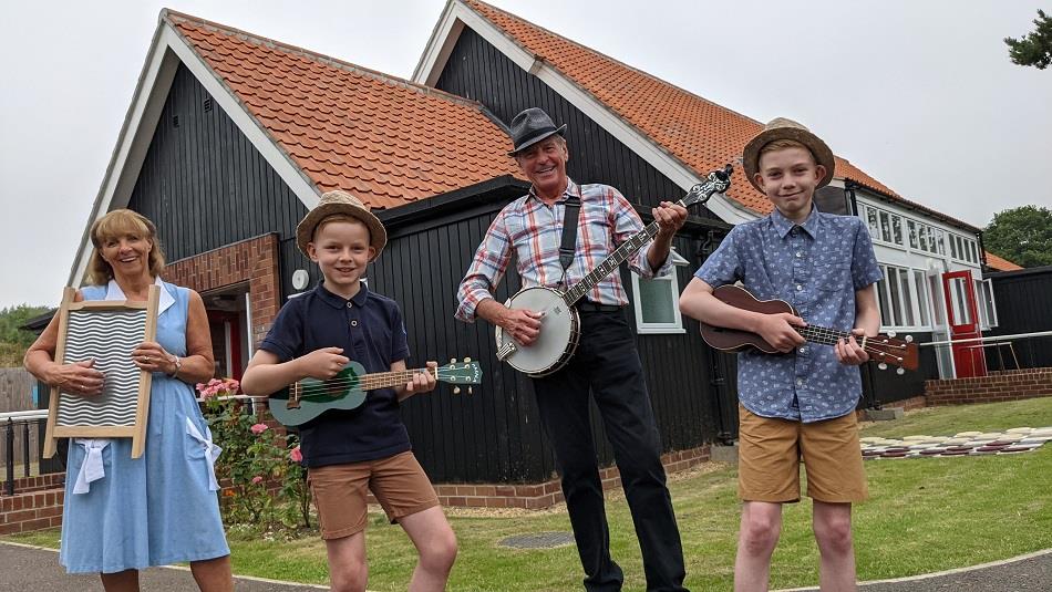 A Skiffle group of two adults and two children in front of Beamish Museum's 1950s welfare hall.