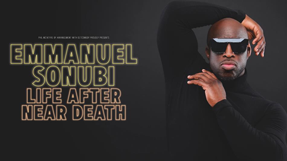 Emmanuel Sonubi wearing sunglasses and posing with one arm behind his head