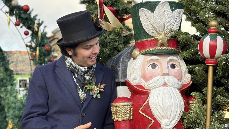 Member of Beamish Museum staff with a Nutcracker figure and festive decorations in the background.