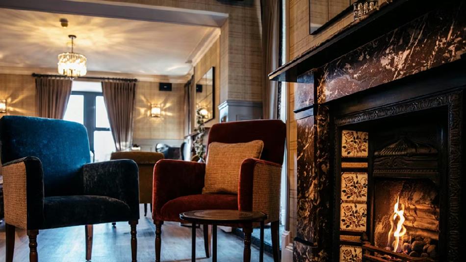 Cosy fireplace surrounded by chairs.