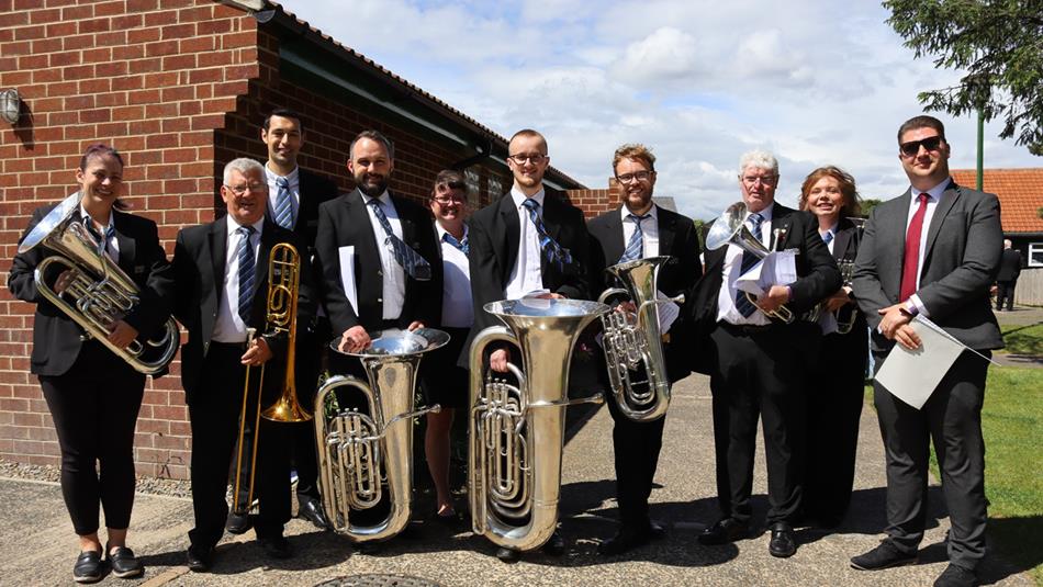 Brass band members with their instruments lining up for a photo at Beamish.