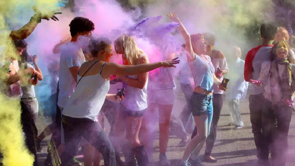 Crowd laughing and covered in colourful powder