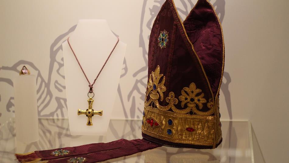 Symbol of the cross on a necklace and a priest's headwear.