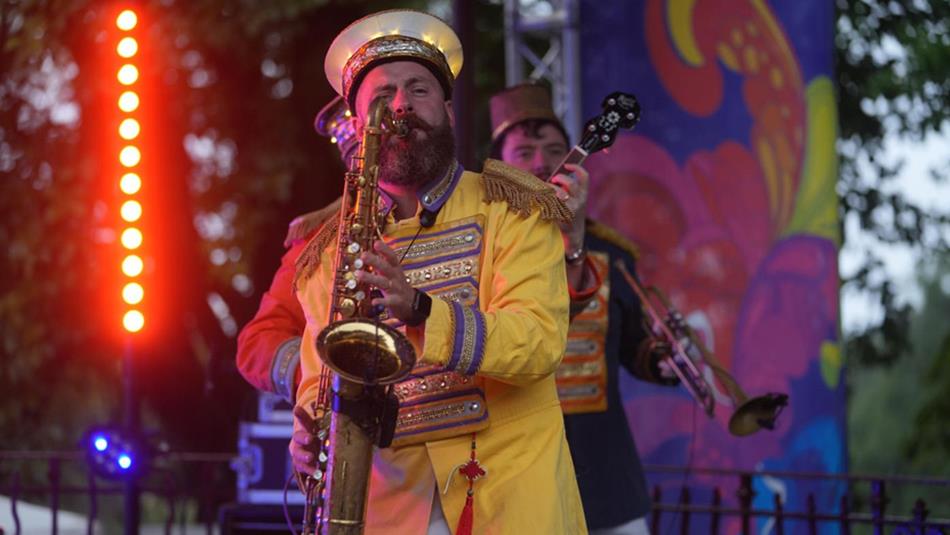 Saxophonist wearing a yellow band jacket, performing at Durham Brass Festival.