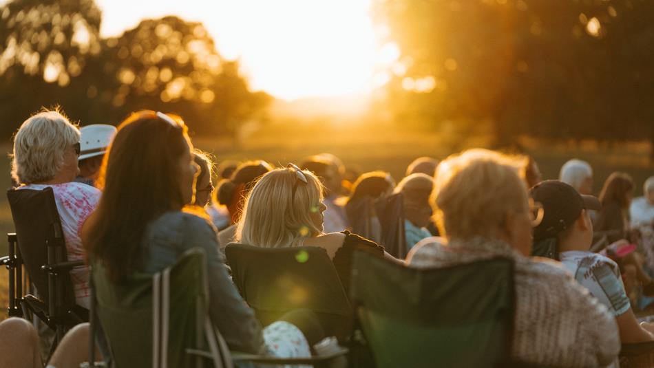 Audience enjoying outdoor cinema in the sunshine at Raby Castle, Park and Gardens.