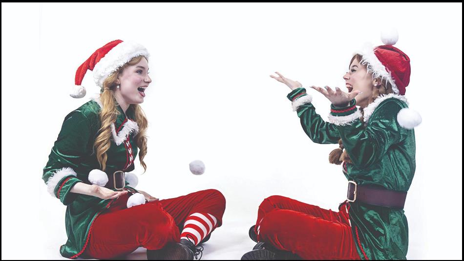 Two elves sitting playing catch with a snowball. laughing.