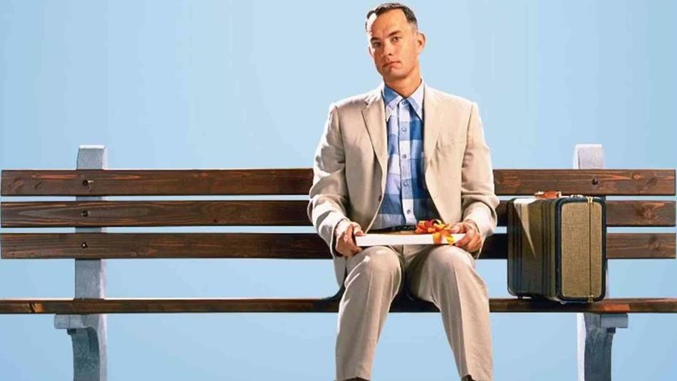 Forrest Gump sitting on a bench with a box of chocolates.