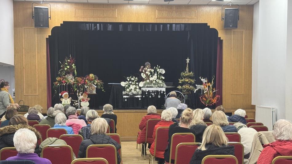 Audience watching a flower demonstration on stage at Ferryhill, Sedgefield and District Flower Club.