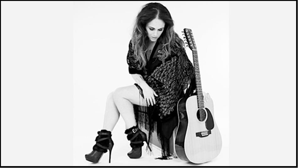 Black and white photo of Sandi Thom with her guitar.