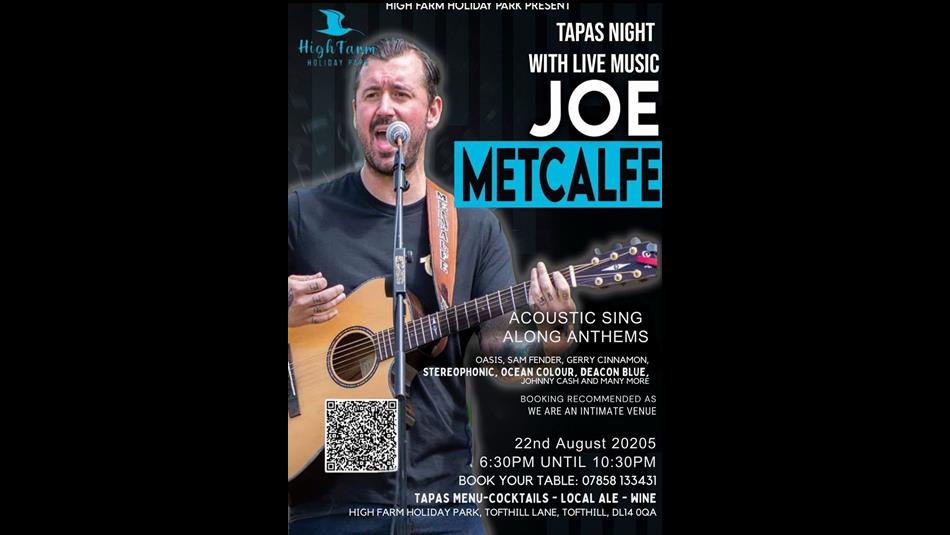 Joe Metcalfe playing guitar and singing on stage
