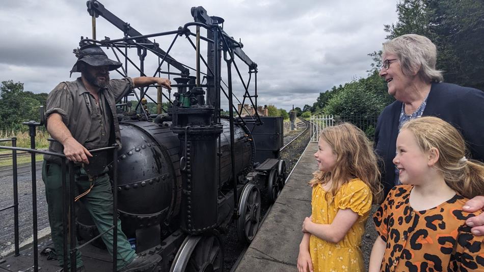 Family speaking to staff on a locomotive at Beamish.