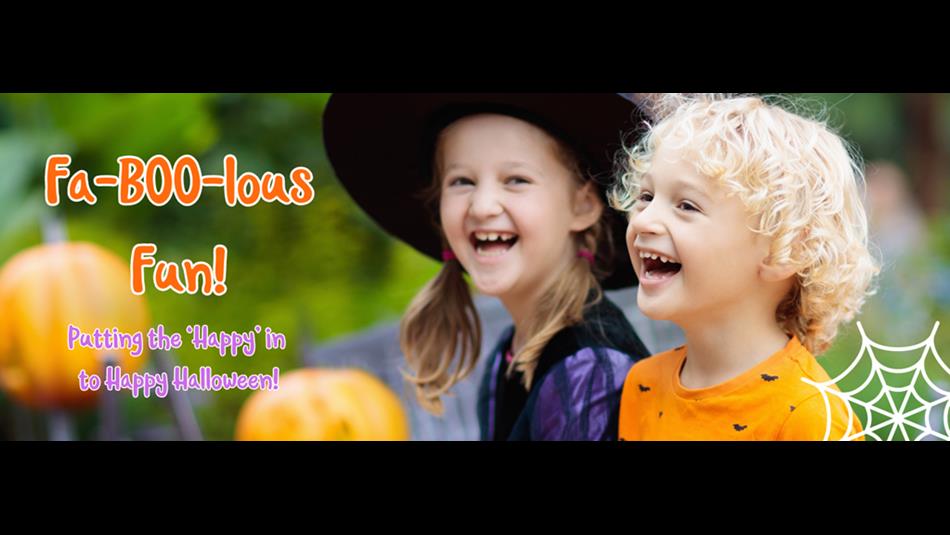Children two children laughing. One dressed as a witch and the other wearing an orange top with a bat pattern.