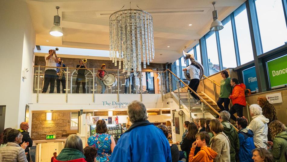 Brass bands performing at The Witham, as crowds watch from below.