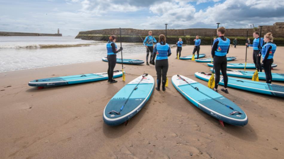 Adults preparing for a SUP lesson at Seaham Harbour Marina