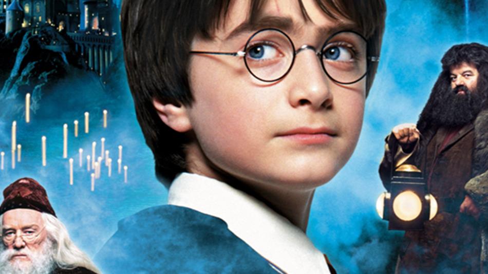 Harry Potter, Hagrid, Dumbledore and Hogwarts in the background of 'The Philosopher's Stone' movie poster.