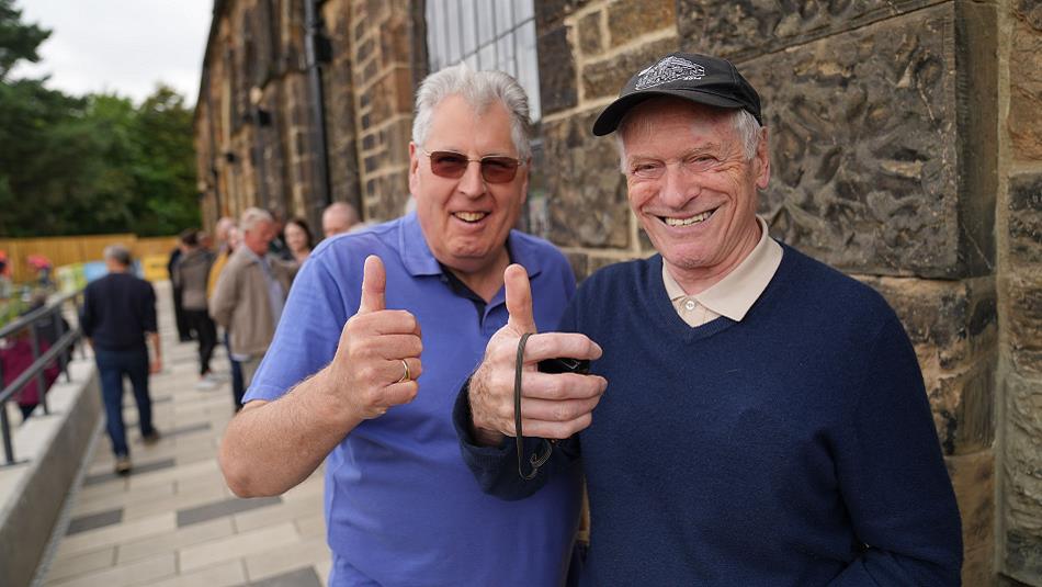 Two gentleman at Hopetown, smiling and  giving a 'thumbs up'.