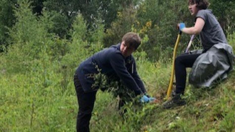 Two teenagers planting trees at Low Barns Nature Reserve