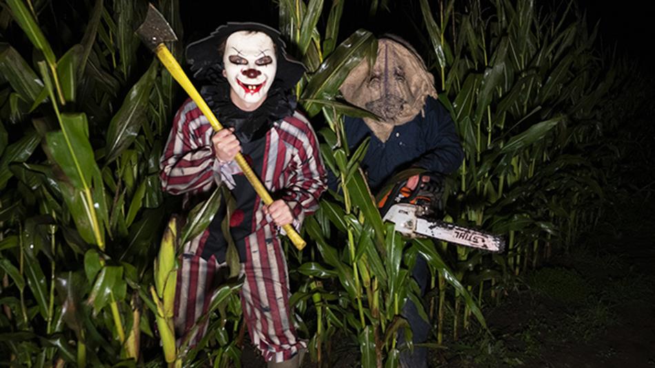 An axe wielding clown and person with a mask and chainsaw - Scare Night at Thorpe Farm Centre.
