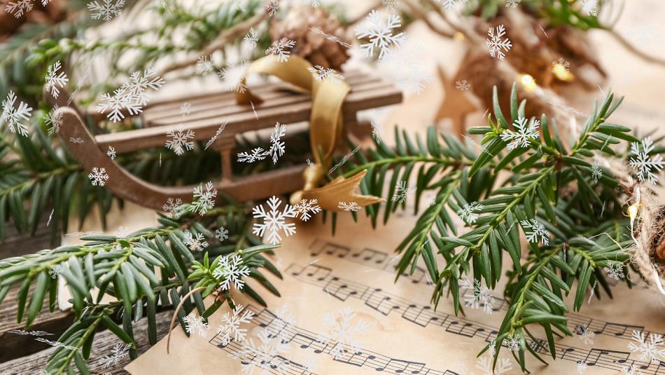 Sheet music with festive greenery on top.